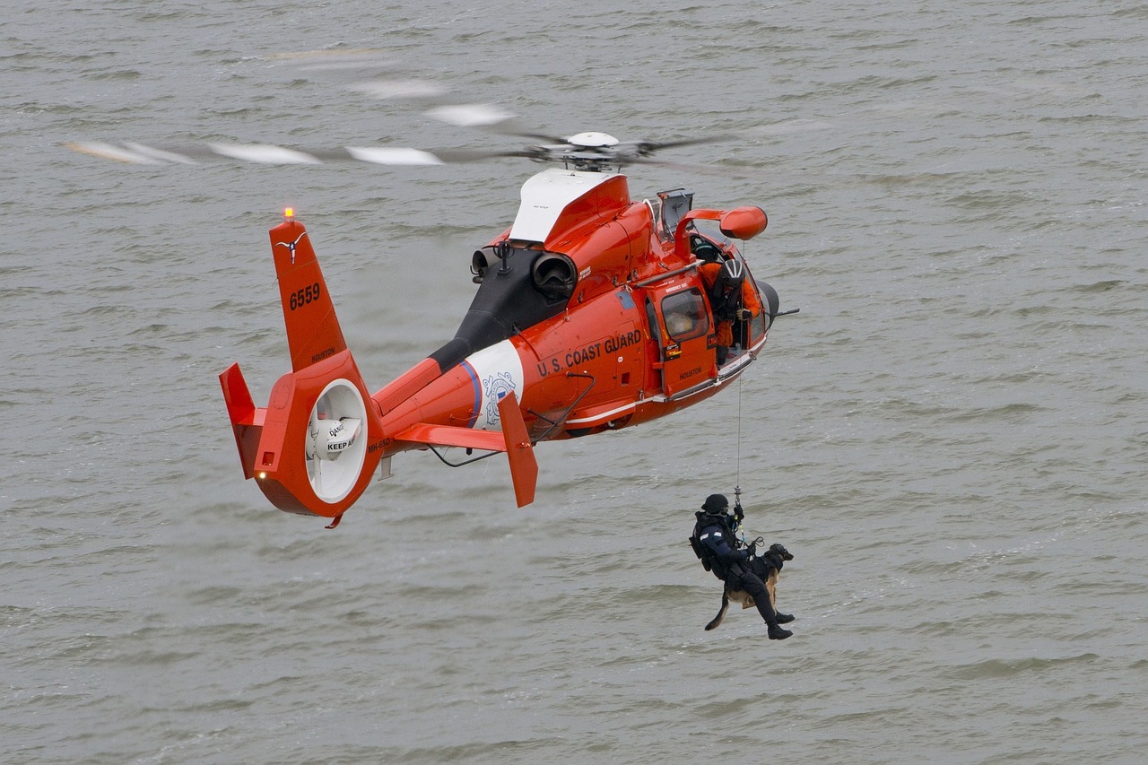 US Coast Guard Helicopter with a man suspended saving a dog