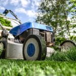 A Lawnmower on a lawn mowing grass on someones yard