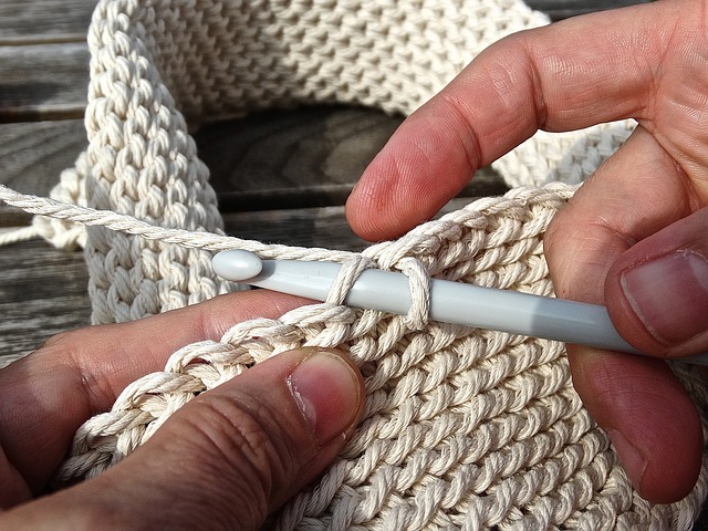 a person crocheting white yarn