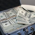 A suitcase full of 100 dollar bills. Currency from the United States. Article about how to save or finance for the holidays and black Friday shopping.