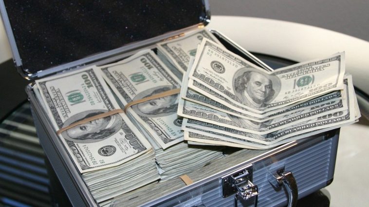 A suitcase full of 100 dollar bills. Currency from the United States. Article about how to save or finance for the holidays and black Friday shopping.