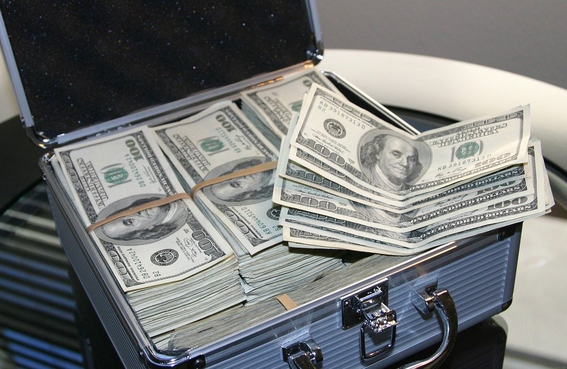 A suitcase full of 100 dollar bills. Currency from the United States. Article about how to save or finance for the holidays and black Friday shopping.