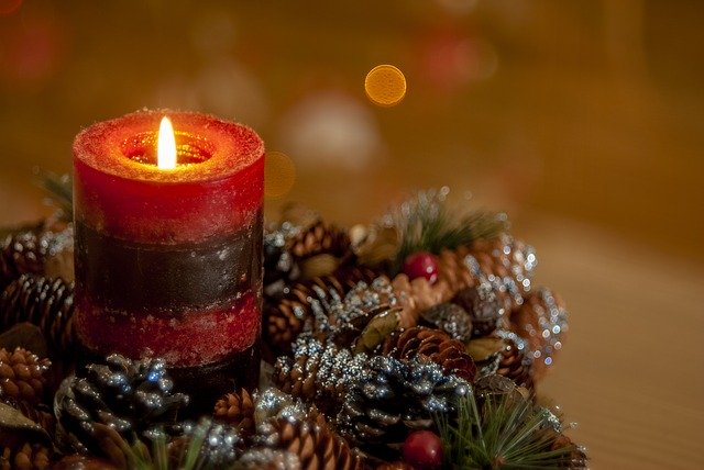 Photo of a candle with Christmas decorations. Article about actives to do if you are alone on Christmas